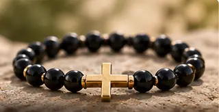 Schwarzes Perlenarmband mit goldfarbenem Kreuz – Symbolmotiv