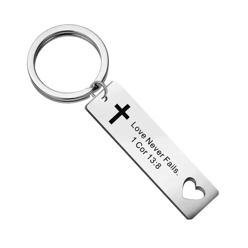 Schlüsselanhänger mit Kreuz und Herzöffnung – 1. Korinther 13,8 – Liebe bleibt – englische Inschrift