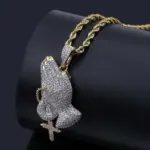 Kette mit betenden Händen und Kreuz, funkelnder Anhänger an goldfarbener Kordelkette