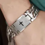 Silberfarbenes Panzerarmband mit Kreuz und spanischem Vaterunser am Handgelenk