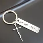 Schlüsselanhänger Let God Lead mit Faith-Kreuz auf dunkler Unterlage