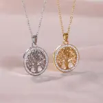 Runde Lebensbaum-Anhänger in Goldfarben und Silberfarben auf rosa Stoff