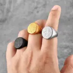 Benediktusringe mit christlicher Kreuzmedaille in Gold-, Silber- und Schwarzoptik an der Hand