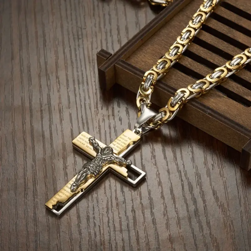 Gold-silberfarbene Byzantinerkette mit Kruzifix auf einer hölzernen Schmuckfläche