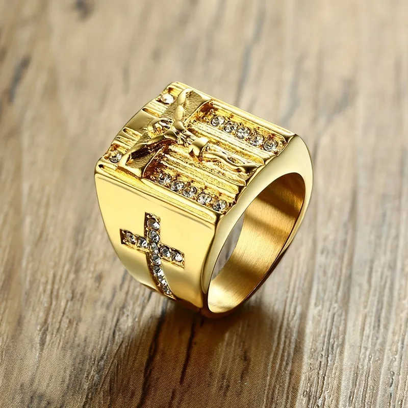 Goldfarbener VNOX Jesus-Kreuzring mit rechteckigem Ringkopf auf Holz fotografiert