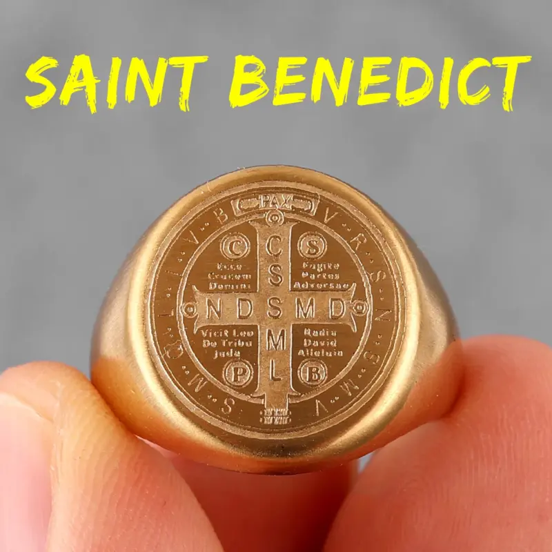 Goldfarbener Benediktusring R694 mit Kreuz und traditionellen Benediktuszeichen in Nahaufnahme
