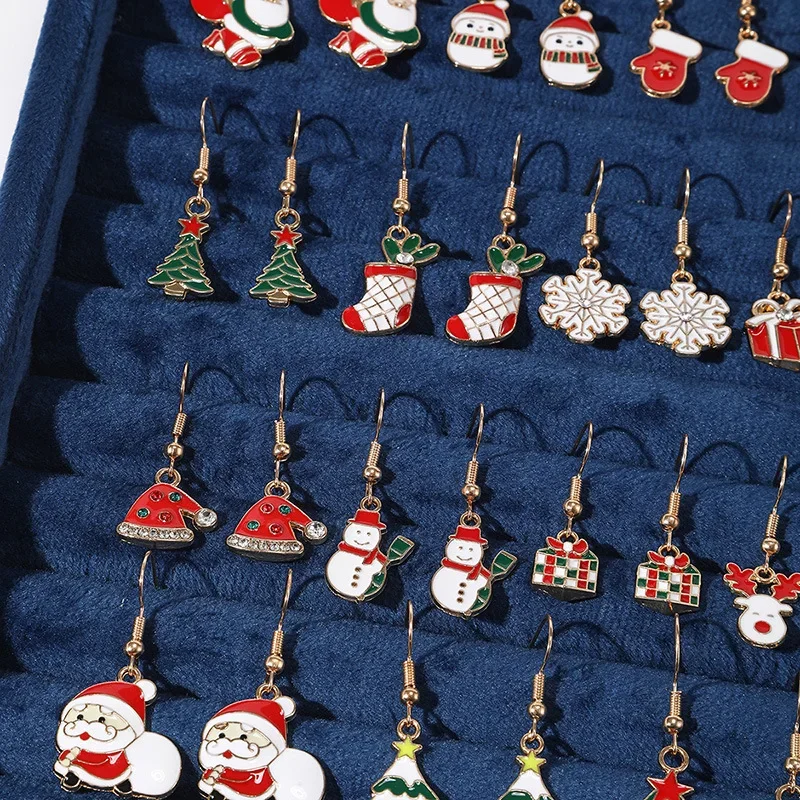 Nahaufnahme weihnachtlicher Ohrhänger als Paare mit Tannenbaum, Nikolausstrumpf, Schneemann und Geschenkpaket