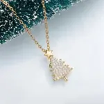 Goldfarbene Huitan Weihnachtsbaum-Kette mit Zirkonia und Stern vor Tannenzweigen