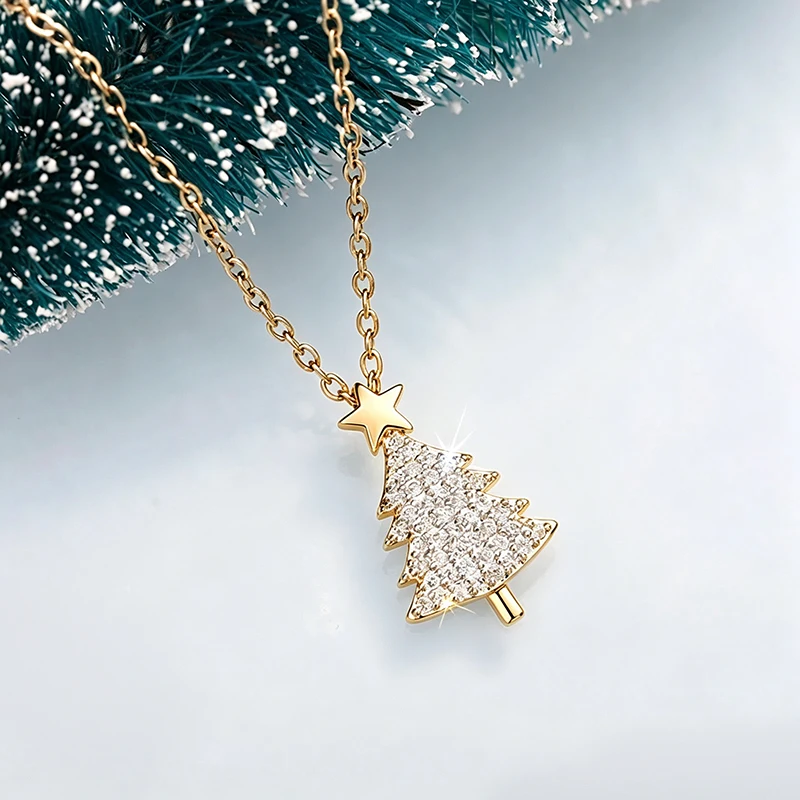 Goldfarbene Huitan Weihnachtsbaum-Kette mit Zirkonia und Stern vor Tannenzweigen