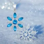 Schneekristall-Halskette mit blauen Zirkonia vor funkelnden Winterdetails
