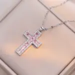 Silberfarbene Kreuzkette mit rosa Schmucksteinen und hellen Randsteinen