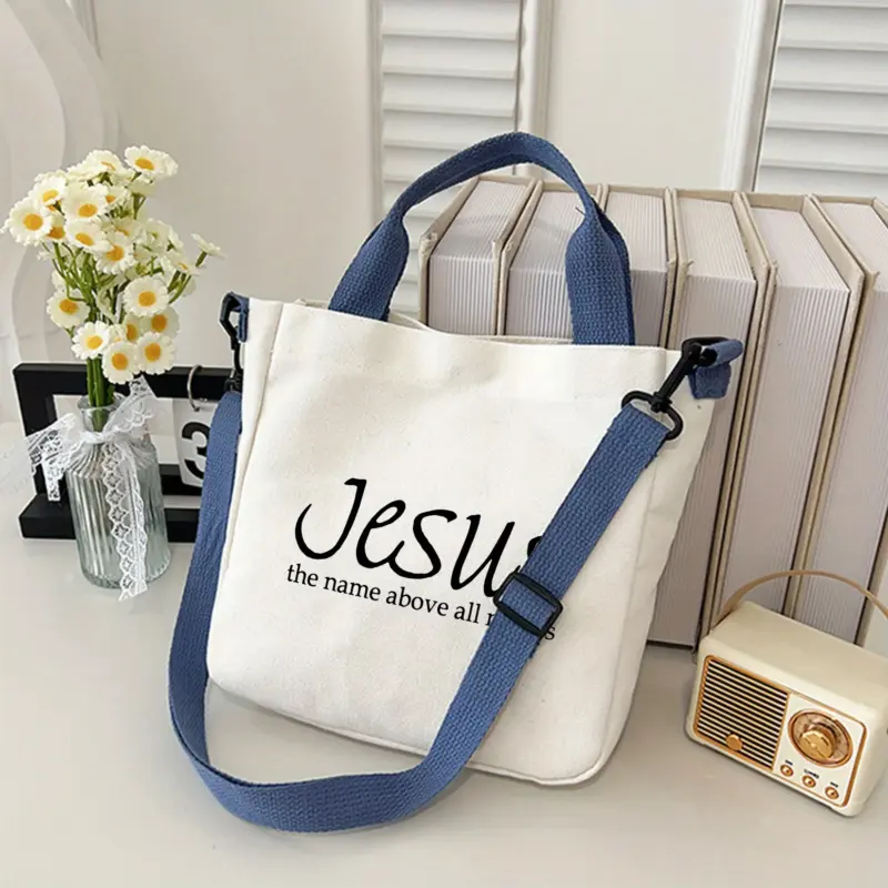 Jesus Schultertasche aus Polyester in heller Stoffoptik mit abnehmbarem blauem Schulterriemen