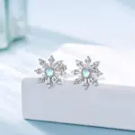 Paar Schneeflocken-Ohrstecker mit Zirkonia auf weißer Auslage