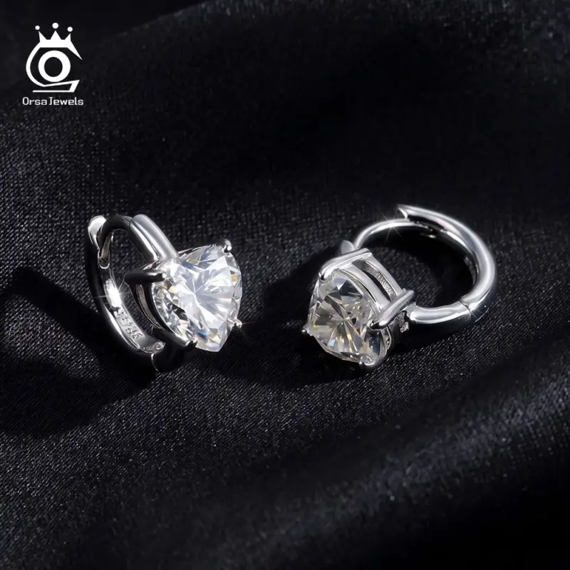 Silberfarbene ORSA JEWELS Herz-Creolen auf dunklem Stoff – 925 Silber laut Anbieter