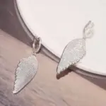 Silberfarbene Huitan Flügelohrringe mit Zirkonia in schräger Ansicht