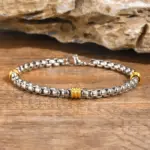 Zweifarbiges VNOX Herrenarmband mit Kastengliedern und goldfarbenen Akzenten auf Holz