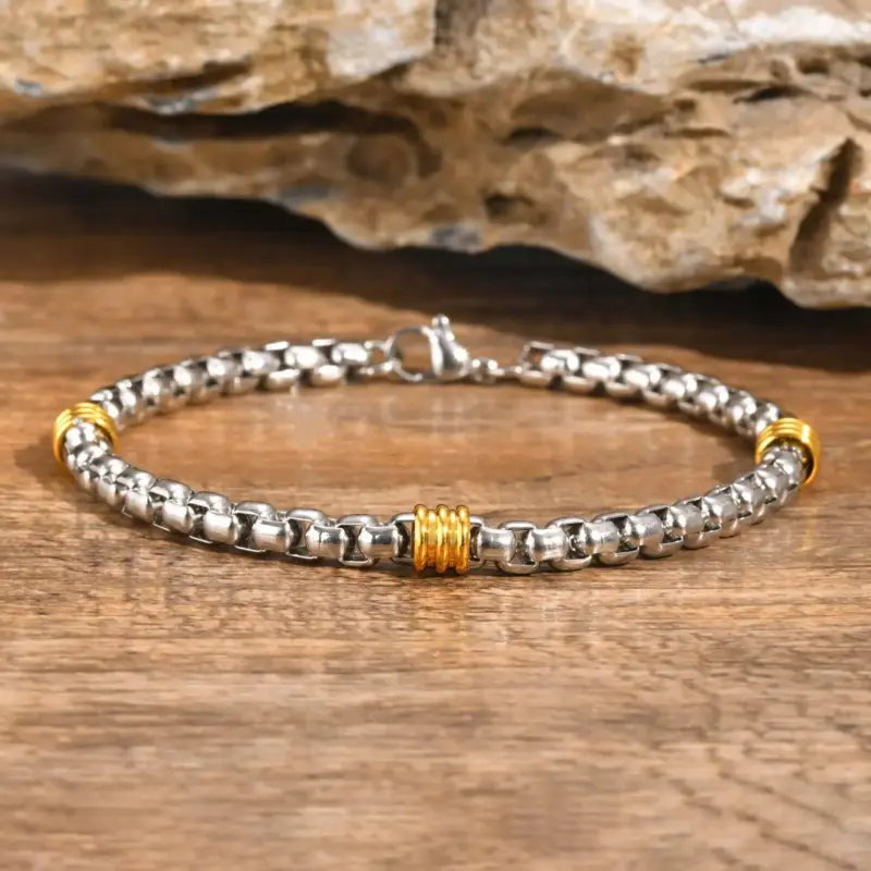 Zweifarbiges VNOX Herrenarmband mit Kastengliedern und goldfarbenen Akzenten auf Holz