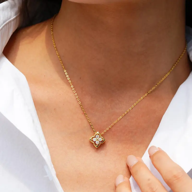 Horripal Kleeblatt-Halskette Design A an einer Person getragen, goldfarbene Kette mit kleinem Anhänger