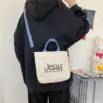 Christliche Jesus-Schultertasche mit blauen Trägern quer über der Schulter getragen, Alltagsaufnahme
