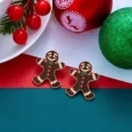 Paar Lebkuchenmann-Ohrringe mit grüner Fliege in festlicher Weihnachtsdekoration