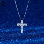 Silberfarbene ORSA JEWELS Kreuzkette mit klaren facettierten Steinen vor dunkelblauem Hintergrund