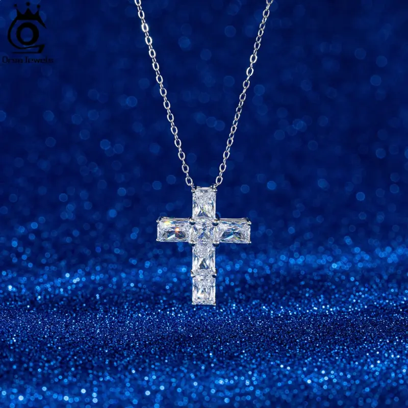 Silberfarbene ORSA JEWELS Kreuzkette mit klaren facettierten Steinen vor dunkelblauem Hintergrund