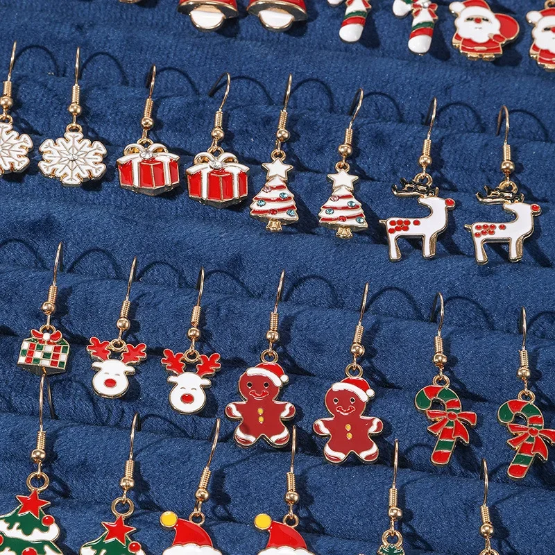 Detailaufnahme goldfarbener Weihnachts-Ohrhänger mit Schneeflocke, Rentier, Lebkuchenfigur und Zuckerstange