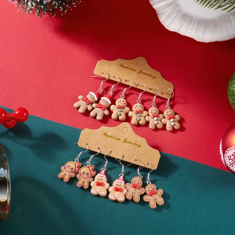Zwei Fotobeispiele von jeweils drei Paar Lebkuchenmann-Ohrringen auf Schmuckkarten vor weihnachtlichem Hintergrund