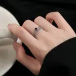 VENTFILLE Damenring mit Blattmotiv und schwarzem Schmuckstein an einer Hand mit hellem Becher