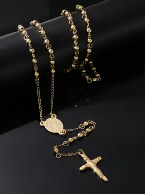 Rosenkranzkette goldfarben mit ovaler Marienmedaille und Kruzifix auf dunklem Hintergrund