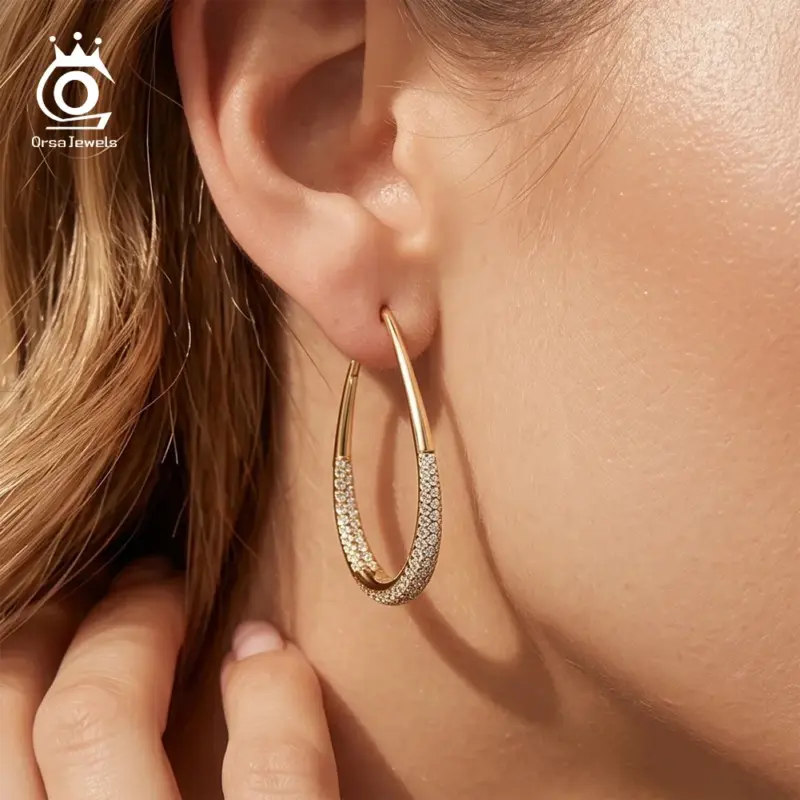 ORSA JEWELS Tropfen-Creolen in Goldoptik am Ohr im Größenvergleich