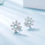 Huitan Schneeflocken-Ohrstecker in Silberoptik mit blau schimmernder Steinmitte auf hellem Hintergrund