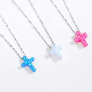 TONGZHE Opal-Kreuzanhänger in Blau, Weiß und Rosa an silberfarbenen Halsketten auf hellem Hintergrund