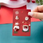 Weihnachtsmann und Weihnachtsfrau als verschiedene Ohrsteckermotive auf roter Weihnachtskarte