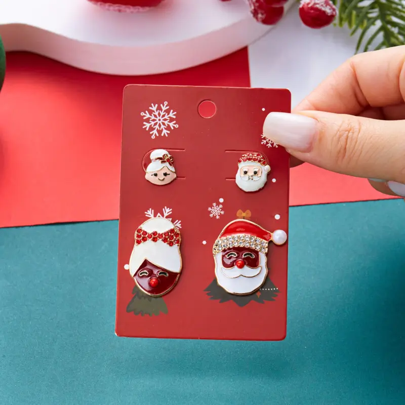 Weihnachtsmann und Weihnachtsfrau als verschiedene Ohrsteckermotive auf roter Weihnachtskarte