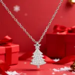Silberfarbene Huitan Weihnachtsbaum-Halskette mit Zirkonia und Stern vor festlicher roter Geschenkdekoration