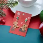 Ein Paar Lebkuchenmann-Weihnachts-Ohrhänger auf roter Präsentationskarte