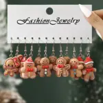 Sechs Paar Lebkuchenmann-Ohrhänger auf weißer Schmuckkarte mit rot-weißen Weihnachtsdetails