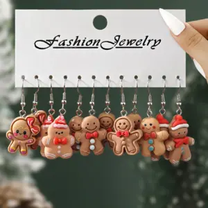 Sechs Paar Lebkuchenmann-Ohrhänger auf weißer Schmuckkarte mit rot-weißen Weihnachtsdetails