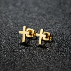 oly2u kleine Kreuz-Ohrstecker als goldfarbenes Paar aus Edelstahl laut Anbieter – auf dunklem Hintergrund